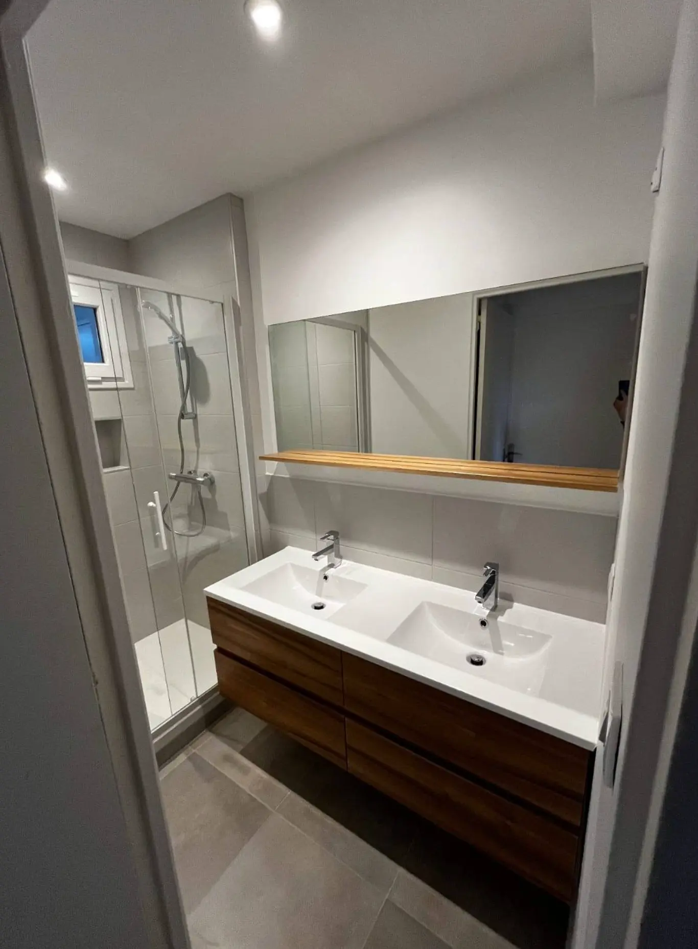 Salle de bain rénovée avec double vasque et douche à l'italienne